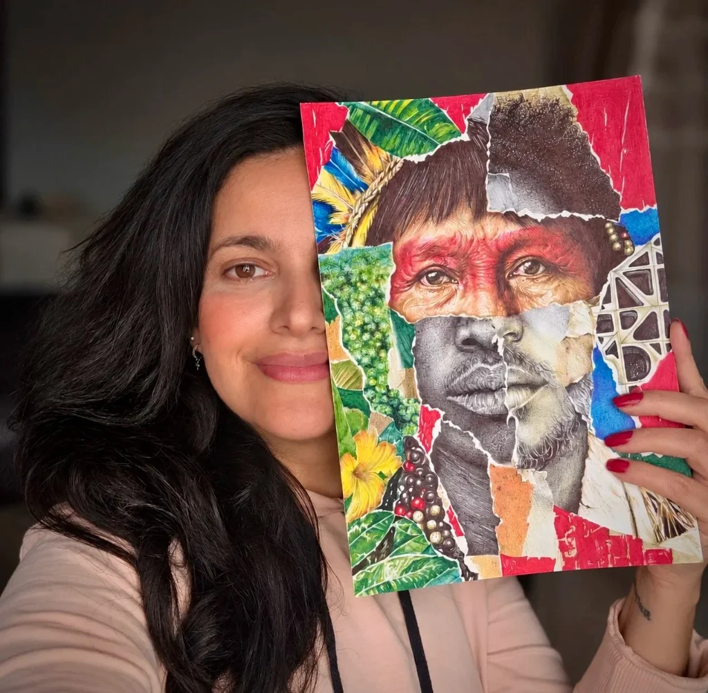 Cíntia Cris holding the finished work A Cara do Brasil in front of part of her own face.