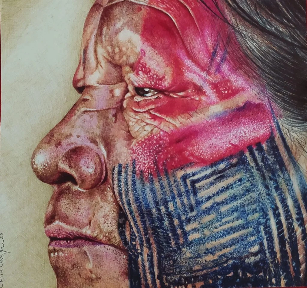Profile portrait of an Indigenous person, drawn in ballpoint pen by Cíntia Cris, with red body paint and geometric patterns in blue and black. Based on a photograph credited to @zaremare.